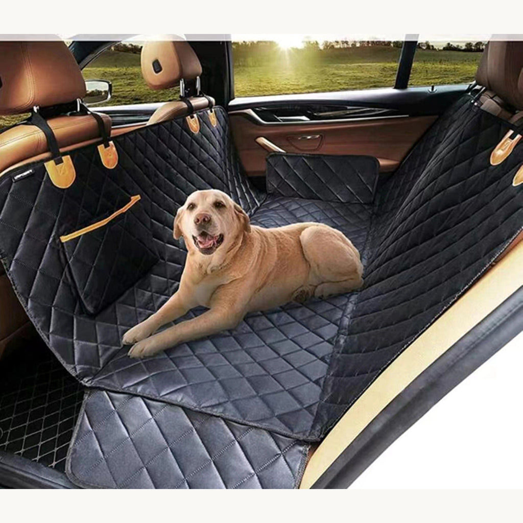 Labrador lying on the quilted hammock seat cover across the back seat of a car