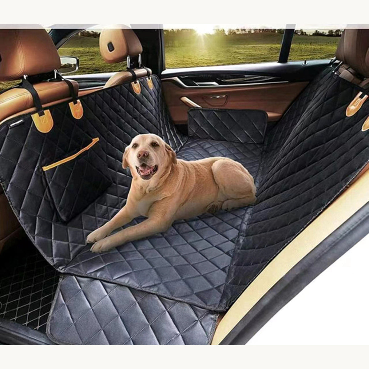 Labrador lying on the quilted hammock seat cover across the back seat of a car