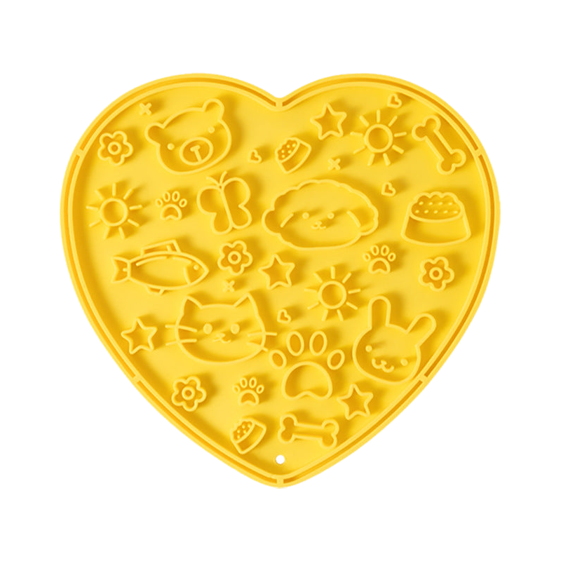 Yellow heart-shaped silicone lick mat, top view on a white background